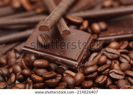 Pieces of chocolate, coffee beans and chocolate sticks.