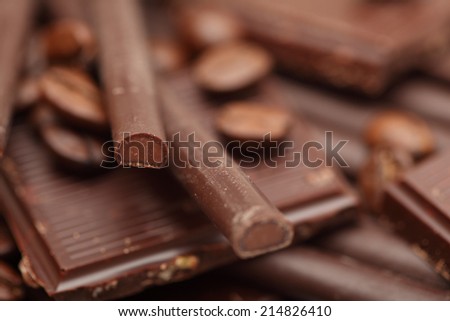 Pieces of chocolate, coffee beans and chocolate sticks.