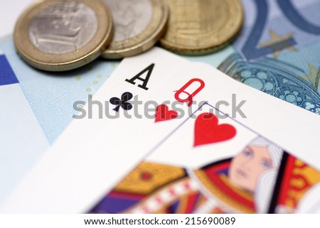 The Ace Of Clubs and Queen of Hearts playing cards on money background.