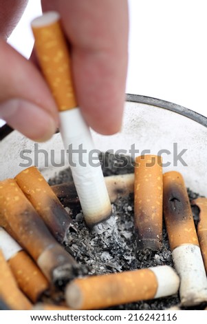 Bad addiction. Cigarette in woman\'s hand. Ashtray and cigarettes closeup.