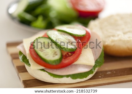 Open homemade hamburger. Fresh ingredients only: Tomato, Cucumber, Cheese,  Lettuce, Turkey breast ham, Bun.