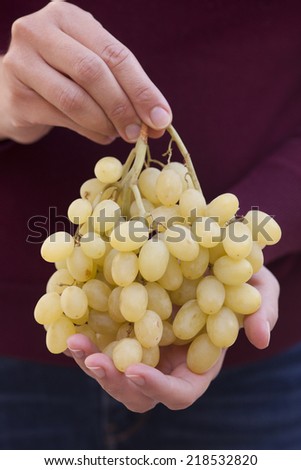 Bunch of green grapes in woman\'s hands.