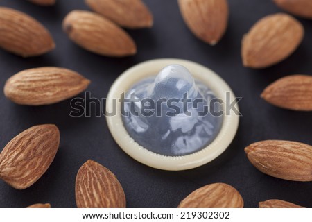 Foods for Your Sex Life. Almonds and condom. Almonds can Improve your sex life (libido). Concept image about Impotence (Erectile Dysfunction).