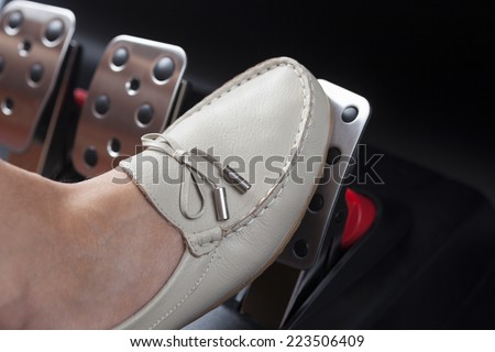 Woman\'s foot pressing the gas pedal.