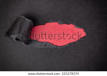 Red paper background appearing behind torn black paper.