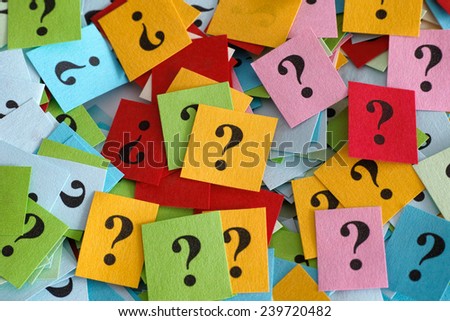 Pile of colorful paper notes with question marks. Close-up.
