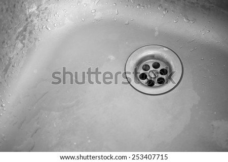 Old dirty sink. Plug hole of a kitchen sink. Black and White image.