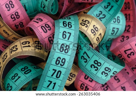 Colorful measuring tapes pile. Close up.