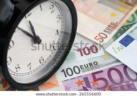 Time is money. Alarm clock and euro banknotes.