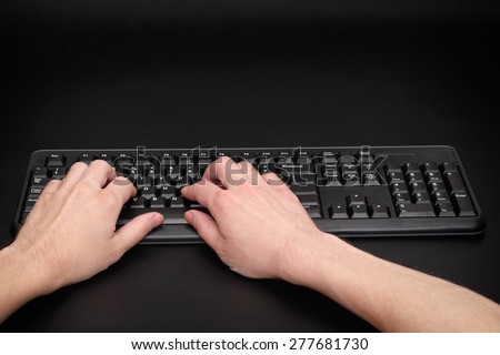 Typing on computer keyboard. Black background.