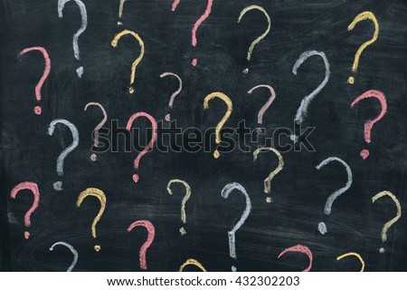 Colorful question marks on chalkboard background. Close up.
