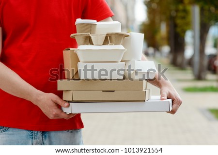 Diverse of paper containers for takeaway food. Delivery man is carrying pizza, Chinese noodles, burgers and coffee.
