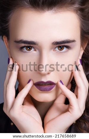 beautiful girl with make-up presses palms to her face