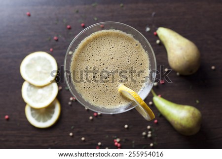 Healthy organic green detox juice on wood with pear,lemon and pineapple