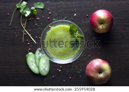 healthy organic green detox juice on wood with apple, cucumber and mint.