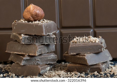 Milk chocolate with hazelnut. Black base, brown chocolate in the background.