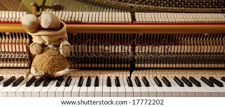 Piano keyboard and teddy bear in upside down position - frustrated in waiting for inspiration concept