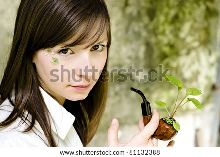 Attractive girl with tobacco pipe filled with green plant - rehab concept, anti smoking