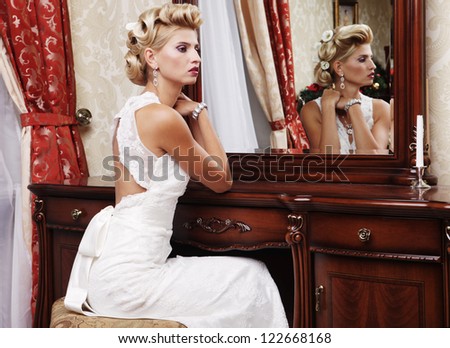 young bride looks at herself in the mirror