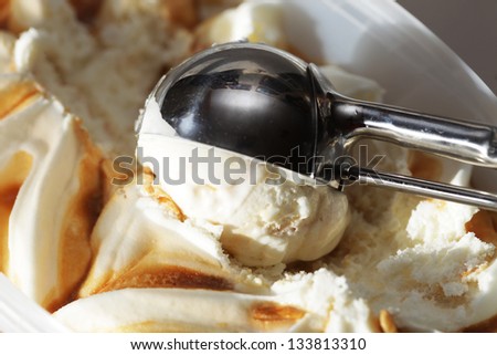 creamy caramel ice cream in a white cup with a special spoon