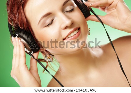 woman with headphones listening to music over green background