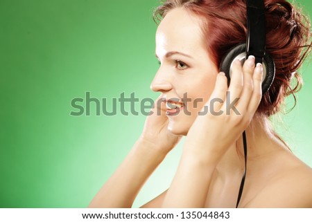 woman with headphones listening to music over green background