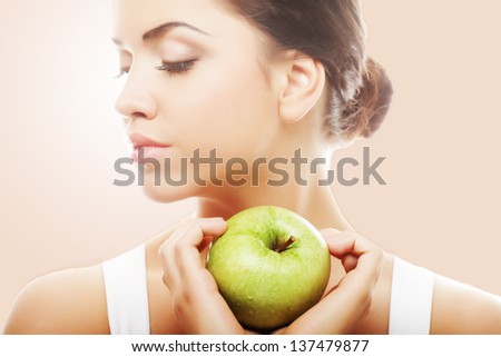 Head shot of woman holding green apple