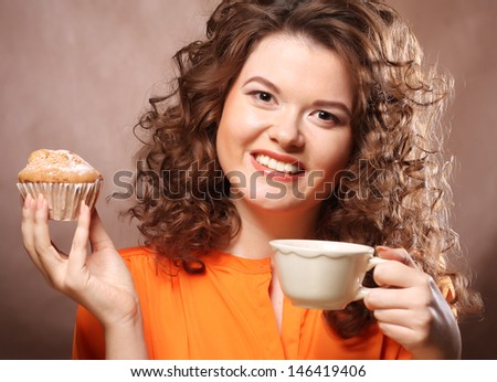 Woman eating cookie and drinking coffee.