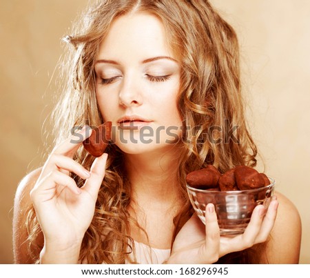 blond girl in act to eat a chocolate candy