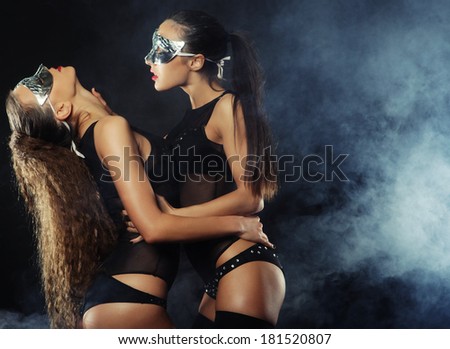 two young sexy striptease dancer with mask