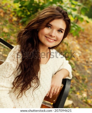 happy girl on bench in autumn park