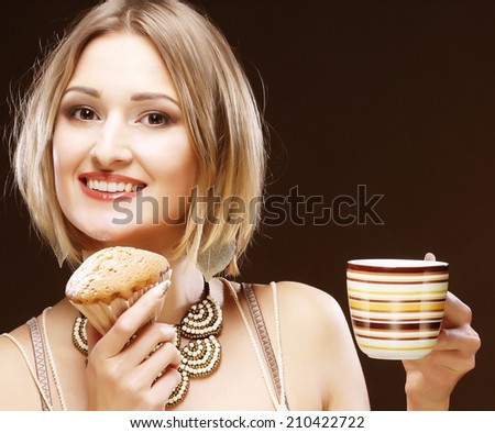 Woman eating cookie and drinking coffee. Cute adorable beautiful young female model.