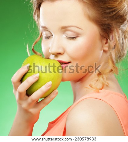 Young smiling sharming woman with green apple over green background