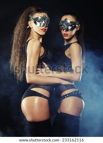two young sexy striptease dancer with mask, dance in smoke