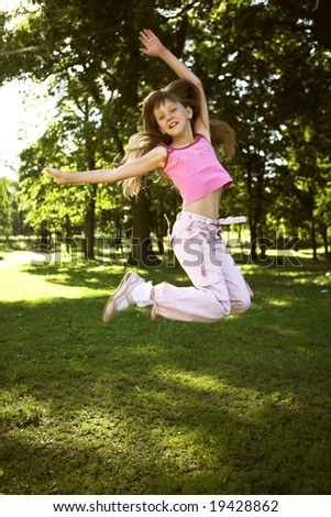 little girl jumping in  summer park