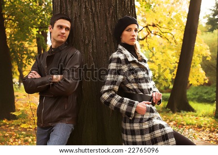 The young couple which has quarrelled during their walk in a park
