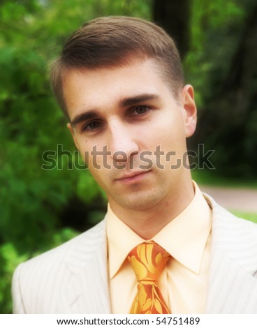 Portrait of a handsome man in business suit during his walk in a park