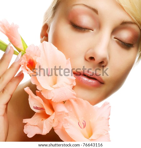 Close-up beautiful fresh face with gladiolus flowers in her hands