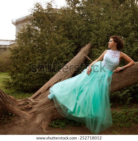 Young  woman in elegance dress posing in the garden. Summer day.