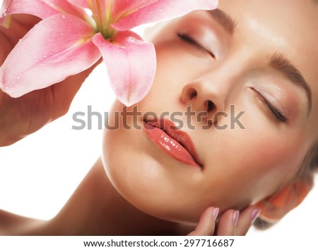 Beauty face of the young woman with pink lily isolated on white