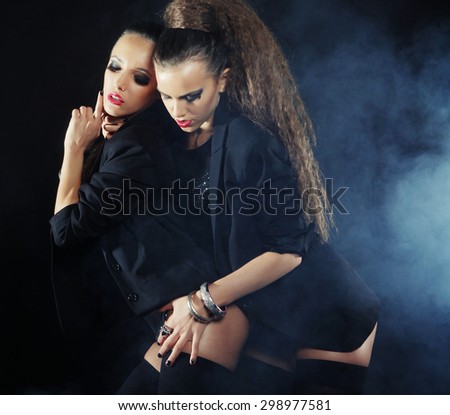 Two sexy dancing woman in black lingerie, night club.