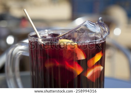 pitcher of cold sangria under the hot sun, red wine with fruit pieces and ice cubes, Spain