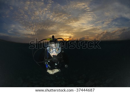 Scuba Diver in water before a sunrise dive at the Liberty Wreck dive site, Tulamben, Bali, Indonesia