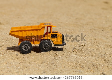 Toy truck circulating through the sand on a sunny day (horizontal shot).
