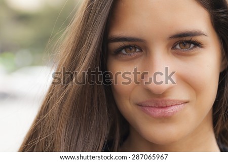 Portrait shot of a beautiful young woman with brown eyes and hair.