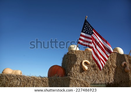American flag at farmers market with pumpkins and hay