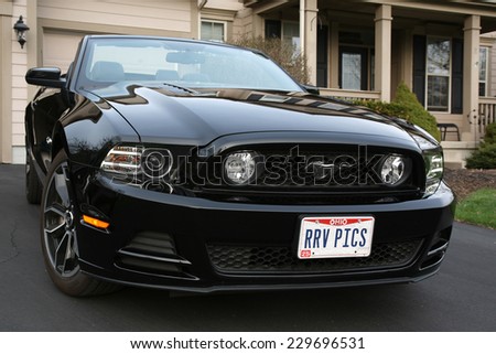 COLUMBUS, OHIO - CIRCA APRIL 13, 2014: A black 2014 Ford Mustang GT convertible parked in driveway.