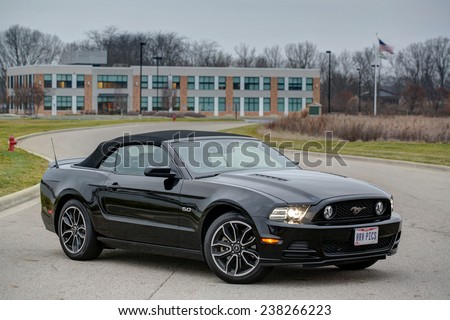 COLUMBUS, OHIO - CIRCA DECEMBER 14, 2014: A black 2014 Ford Mustang GT convertible idles on a road.