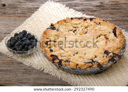 Blueberry pie and berries on rustic wooden table with place mat