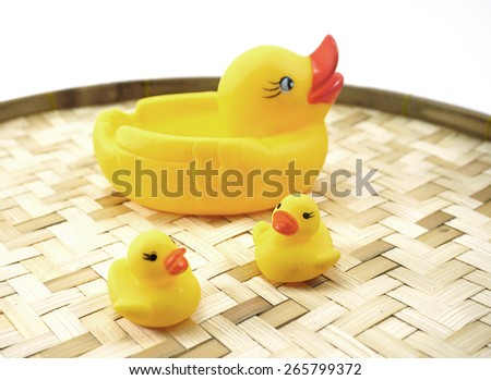 isolated of three rubber ducks ( one big and two smalls) on bamboo woven basket